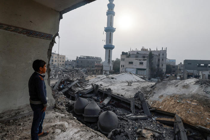 A child standing inside a damaged building stares at the Al-Faruq mosque, leveled by Israeli bombardment in Rafah on a foggy day on Sunday, Feb. 25.