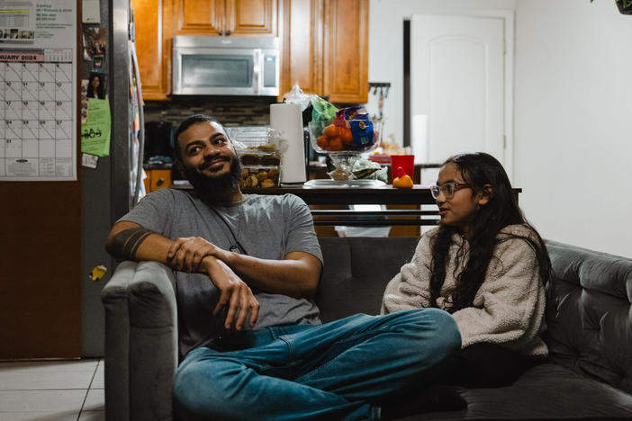 Christopher Santiago, 38, hangs out at home in Alsip, Ill., with one of his three children, 9-year-old Calliope. He says Cook County's basic income program has let him provide more for his kids.