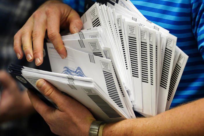 A local election official organizes mail-in ballots to be sorted for the 2020 general election in West Chester, Pa.
