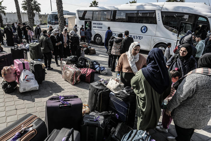Palestinians holding foreign passports collect their luggage as they prepare to cross to Egypt from the Gaza Strip through the Rafah border crossing on Feb. 6.