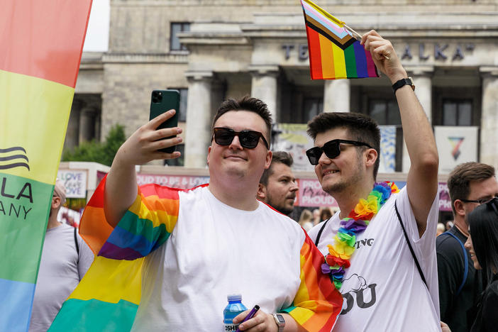 People take a selfie with rainbow Pride flags before the start of the Equality Parade in Warsaw, Poland, in June 2023. The Equality Parade was celebrated under the slogan "We predict equality and beauty!"