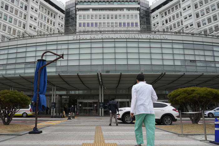 A medical worker walks to enter Seoul National University Hospital in Seoul, South Korea, Thursday, Feb. 29, 2024.