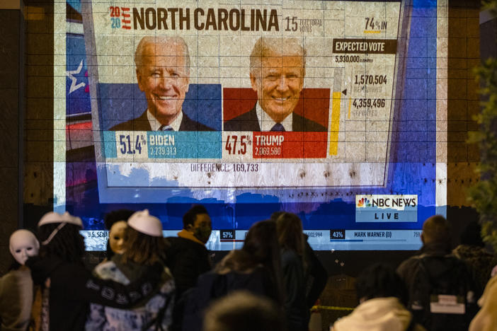People watch a projection on the side of a building in Washington, DC as poll reports begin to roll in Election Day, November 3, 2020 in Washington, DC. After decisive primaries in Michigan and South Carolina, the 2024 race for President is shaping up to be a rematch.