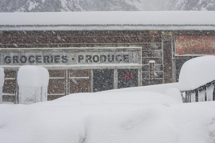 Snow covers the landscape in front of a store, during a storm on Saturday in Truckee, Calif.