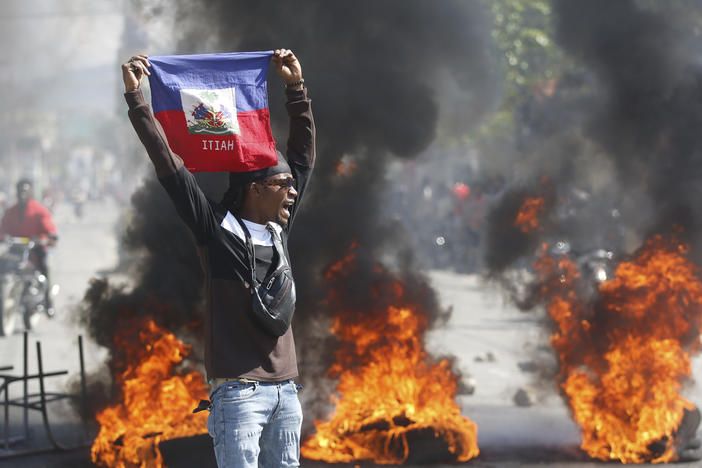 A demonstrator holds up a Haitian flag during protests demanding the resignation of Prime Minister Ariel Henry in Port-au-Prince, Haiti, on Friday.