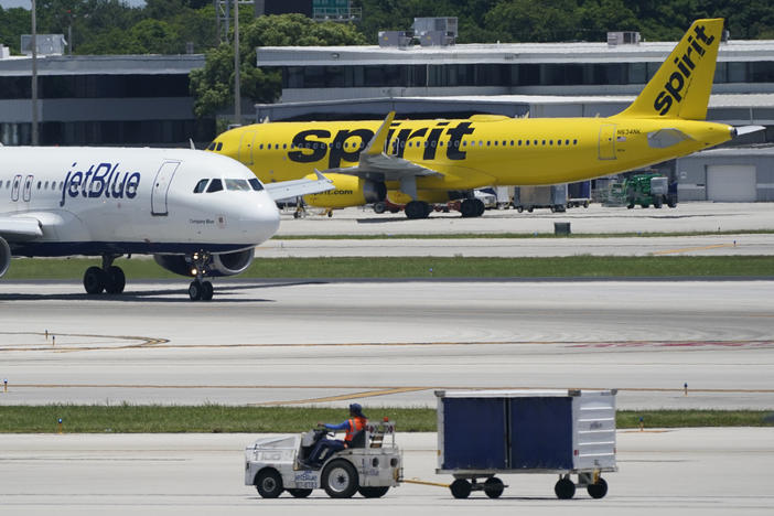 A JetBlue Airways Airbus A320, left, passes a Spirit Airlines Airbus A320 as it taxis on the runway, July 7, 2022, at the Fort Lauderdale-Hollywood International Airport in Fort Lauderdale, Fla. JetBlue and Spirit Airlines are ending their proposed $3.8 billion combination after a court ruling blocked their merger.