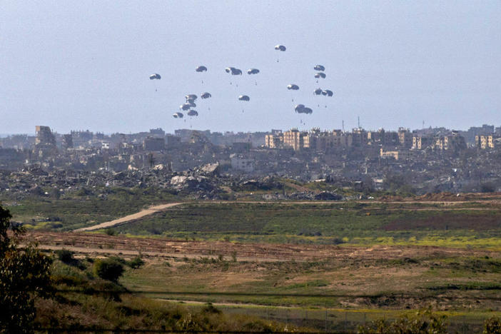 A general view taken from the Israeli side of the border shows aid parcels being airdropped over the northern Gaza Strip on Tuesday. Belgium sent a military transport plane Monday to join an international operation to airdrop aid into Gaza also involving the United States, France and Jordan, officials said.