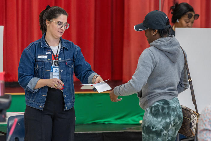 Poll workers assist voters on Super Tuesday at the First Ward Creative Academy, Mecklenburg County Precinct 13 on Tuesday in Charlotte, N.C.