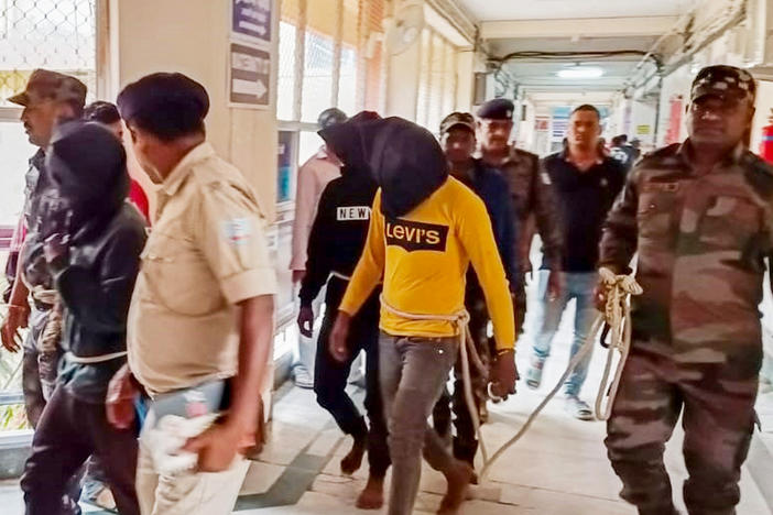 Police escort men accused of allegedly raping a tourist to a district court in Dumka, in India's Jharkhand state, on March 4. The attack took place on March 1; the woman posted a video describing what happened on social media.