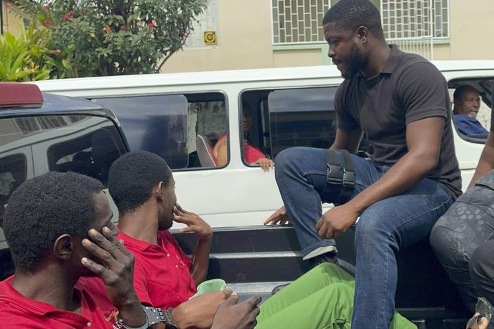 Police transport escaped prisoners Atiba Stanislaus (far left) and Trevon Robertson in Kingstown, St. Vincent and the Grenadines, on Monday. The men had escaped from a police holding cell in Grenada on Feb. 18 and are suspected of hijacking a catamaran while Ralph Hendry and Kathy Brandel, who disappeared, were aboard.