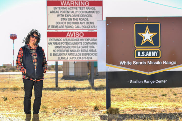 Tina Cordova poses in front of the entrance of White Sands Missile Range where Trinity test site is located. Cordova who is one of five generations in her family diagnosed with cancer since 1945, and runs the Tularosa Basin Downwinders Consortium. Cordova has been fighting for decades to secure compensation for those affected by the radiation from the Trinity test.