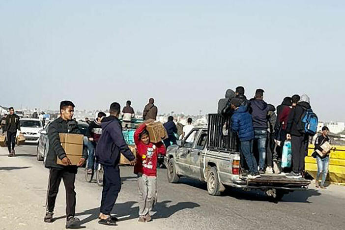 In this image grab from an AFPTV video, people carry food parcels that were airdropped March 2 from U.S. aircraft above a beach in the Gaza Strip. President Biden is set to announce the setting up of another avenue for aid to Gaza.