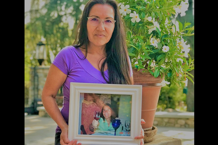 Maria E. Garay-Serratos holds a framed photograph of her mother, who died after suffering decades of domestic violence. Scientists are trying to understand how domestic violence damages the brain.