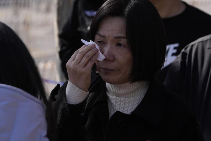 A woman cries as she meets other relatives of passengers on board the missing Malaysia Airline MH370 plane at a security cordon near the Malaysian embassy in Beijing, Friday, March 8, 2024.