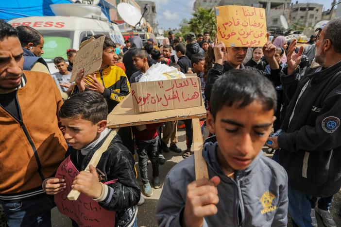 Palestinian children carry banners during a march demanding an end to the war and an end to the famine that citizens suffer from due to the war on Wednesday, March 6, in Rafah, Gaza.