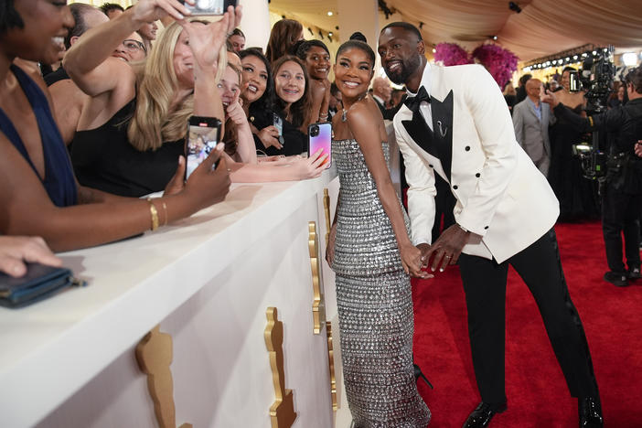 Gabrielle Union and Dwayne Wade pose for a selfie at the Oscars on Sunday, March 10, 2024, at the Dolby Theatre in Los Angeles.