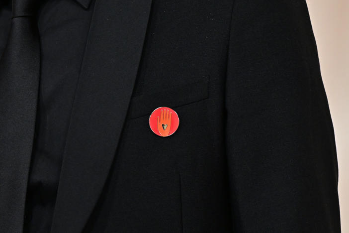 Nadim Cheikhrouha, producer for the Oscar-nominated documentary <em>Four Sisters</em>, wears an Artists4Ceasefire pin as he attends the Academy Awards on Sunday. The pin features a hand with a black heart in the middle of it.