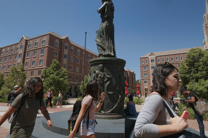 Students walk by the statue of Hecuba, the legendary Queen of Troy, with a quote by William Shakespeare — spelled "Shakespear" — on the campus of the University of Southern California in Los Angeles in 2017.