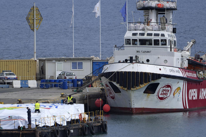 Port staffers prepare aid on a platform near to the docked ship belonging to the Open Arms aid group, as it prepares to ferry some 200 tonnes of rice and flour directly to Gaza, at the port in Larnaca, Cyprus, on Sunday, March 10, 2024.
