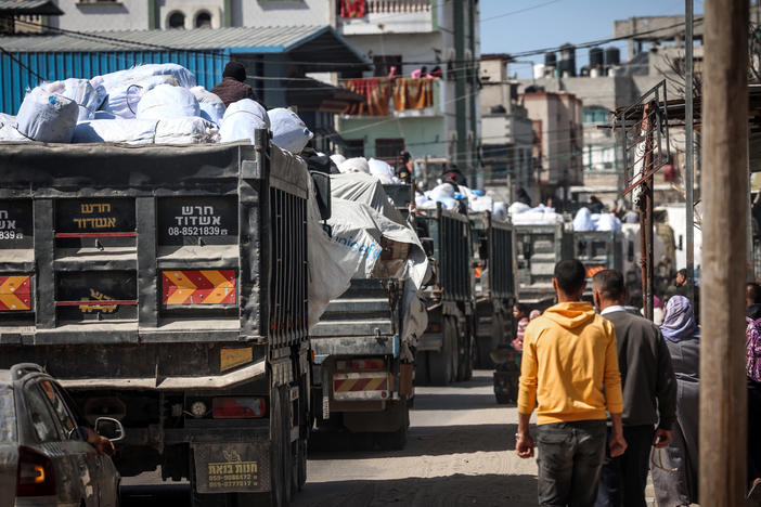Trucks carrying humanitarian aid make their way along a street in Rafah in the southern Gaza Strip.