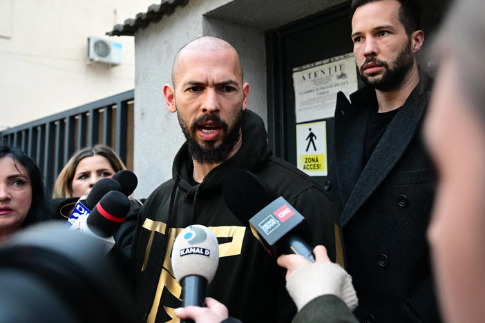 British U.S. former professional kickboxer and controversial influencer Andrew Tate (center) and his brother Tristan Tate (back right) speak to journalists after having been released from detention in Bucharest, Romania, Tuesday.