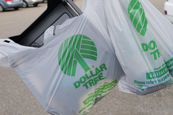 A customer exits a Dollar Tree store holding a shopping bag on Wednesday, May 11, 2022, in Jackson, Miss.