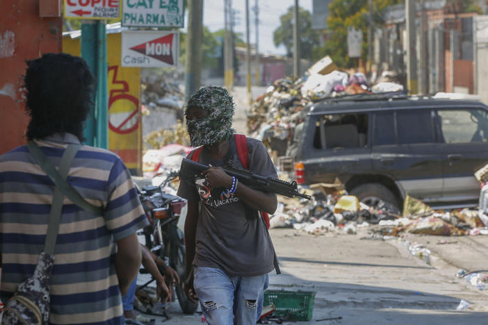 Armed members of the G9 and Family gang stand guard at their roadblock in the Delmas 6 neighborhood of Port-au-Prince, Haiti, Monday.