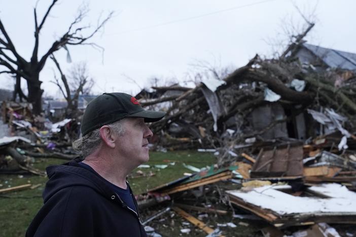 Greg McDougle walks near debris on Friday, following a severe storm in Lakeview, Ohio.