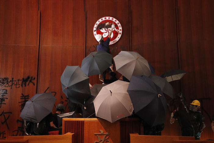 Protesters deface the Hong Kong logo at the Legislative Council to protest against the extradition bill in Hong Kong on July 1, 2019.