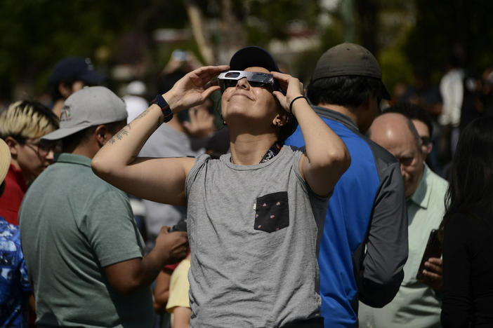 A woman watches an annular solar eclipse on October 14, 2023 using special solar filter glasses at the National Autonomous University of Mexico.