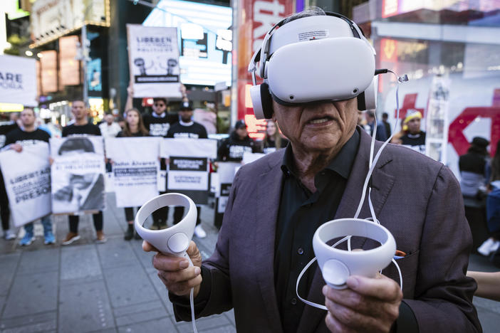 A person standing near Times Square in New York City wears a virtual reality headset screening an immersive experience of the conditions at Venezuela's El Helicoide prison, on Sept. 19, 2023. Protesters gathered to demand the release of political prisoners and the closure of the detention center over allegations of torture.