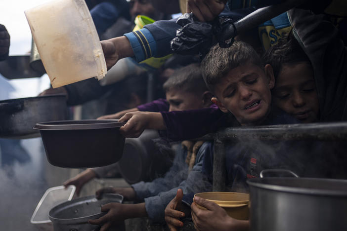 Palestinians line up for a free meal in Rafah, Gaza Strip, Friday, Feb. 16, 2024.
