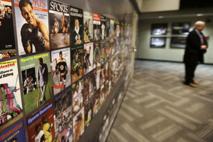 The Sports Museum curator Richard Johnson, right, stands near an exhibit that displays cover photos from the sports magazine Sports Illustrated in the museum at the TD Garden, in Boston.