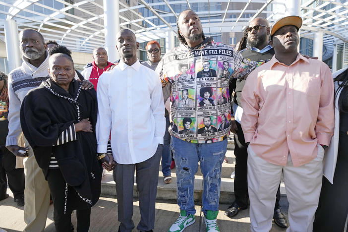 Michael Corey Jenkins, third from left, and Eddie Terrell Parker, right, stand with supporters outside the courthouse in Jackson, Miss., Tuesday, March 19, 2024, calling for harsh penalties against six former law enforcement officers who committed numerous acts of racially motivated, violent torture on himself and his friend Eddie Terrell Parker in 2023.