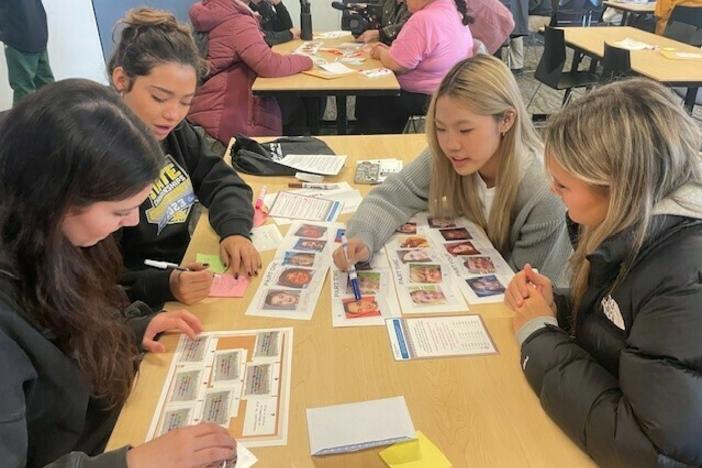 High school students taking part in the University of Washington's annual MisInfo Day earlier this month. They are looking at pictures of faces to tell whether the images were created with generative AI tools or authentic.