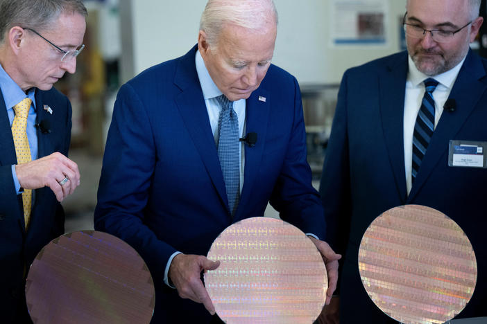 Intel CEO Pat Gelsinger (L) and Intel Factory Manager Hugh Green (R) watch as US President Joe Biden (C) looks at a semiconductor wafer during a tour at Intel Ocotillo Campus in Chandler, Arizona, this week. The White House unveiled almost $20 billion in new grants and loans Wednesday to support Intel's US chip-making facilities.
