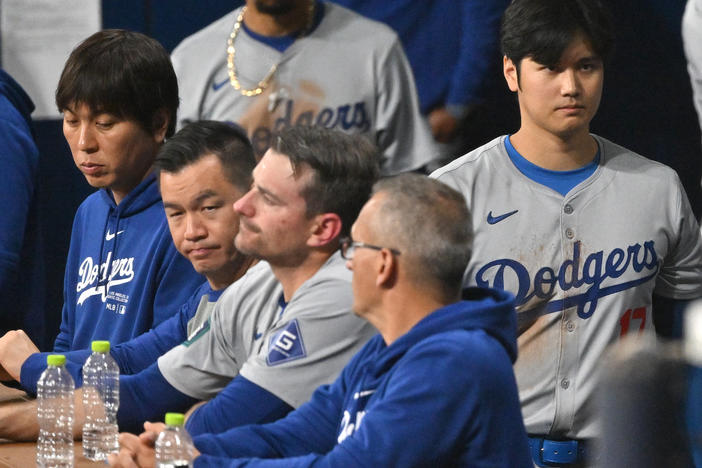 Baseball star Shohei Ohtani (right) and his interpreter, Ippei Mizuhara (left), are seen in the dugout in the 2024 MLB Seoul Series game between the Los Angeles Dodgers and the San Diego Padres. The Dodgers have fired Mizuhara after Ohtani's representatives claimed he was the victim of "a massive theft."