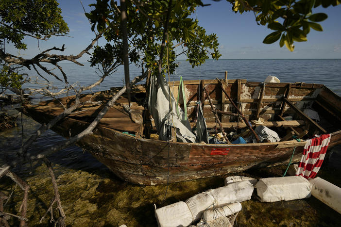 A wooden migrant boat lies grounded on a reef alongside mangroves, at Harry Harris Park in Tavernier, Fla., last year. The U.S. Coast Guard says that since October, has it intercepted and returned about <a href="https://www.news.uscg.mil/Press-Releases/Article/3704408/coast-guard-repatriates-65-migrants-to-haiti/" data-key="28">130 migrants to Haiti</a>.