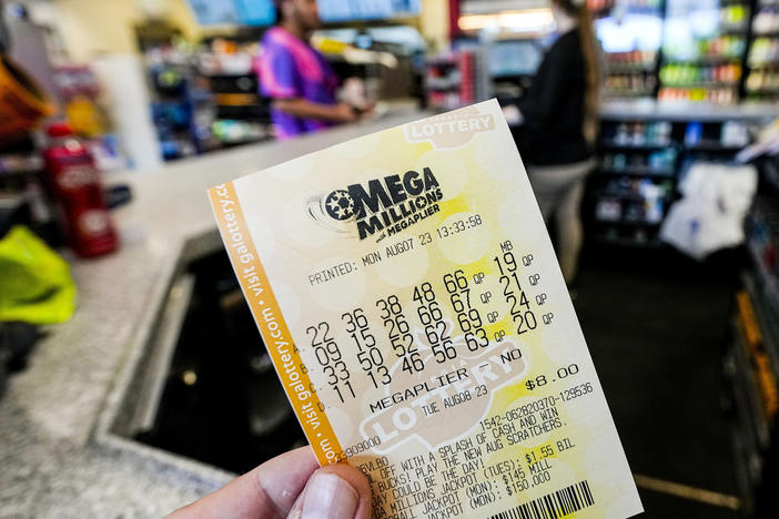 A Mega Millions ticket is seen as a person makes a purchase inside a convenience store, Aug. 7, 2023, in Kennesaw, Ga.