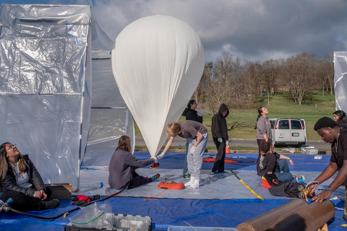 Student volunteers prepare two balloons for a morning launch in Cumberland, Md., as part of a nationwide project to study the April 8 eclipse.