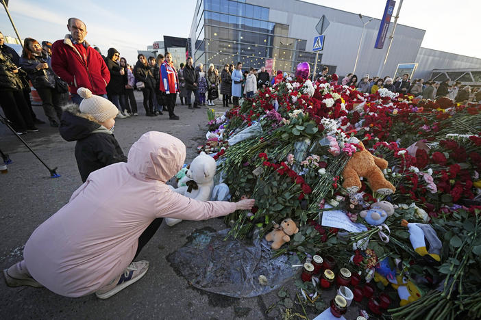 People lay flowers at a makeshift memorial in front of the Crocus City Hall outside Moscow, on Monday. There were calls Monday for harsh punishment for those behind the attack on the Russian concert hall that killed more than 130 people, as authorities combed the burnt-out ruins of the shopping and entertainment complex in search of more bodies.