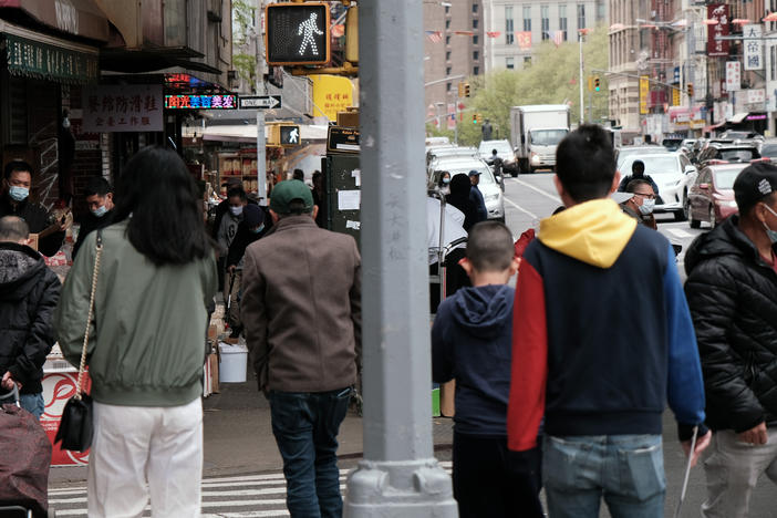 People walk through a busy street in Chinatown in New York City. About 11% of Chinese Americans live in poverty, according to a new analysis by the Pew Research Center.