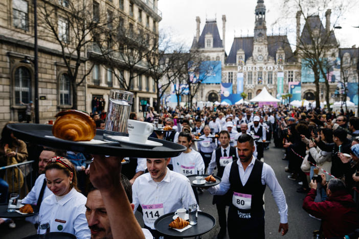 Servers take off for the "<em>Course des Cafes</em>" in front of City Hall in central Paris on Sunday.