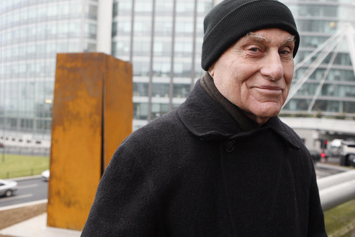 Famed American sculptor Richard Serra poses in front of <em>Slat</em>, a 1984 steel sculpture, after its reinstallation in La Defense, west of Paris, Dec. 15, 2008.