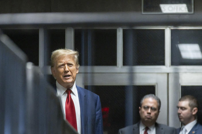 Former President Donald Trump speaks to the press in a hallway outside the courtroom at the end of a hearing to determine the date of his trial for allegedly covering up hush money payments linked to extramarital affairs, at Manhattan Criminal Court in New York City on March 25.