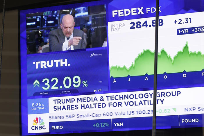 News of Trump Media & Technology Group public trading is seen on television screens at the Nasdaq Marketplace on March 26, 2024 in New York City. At one point, the company was valued at over $9 billion after trading began.