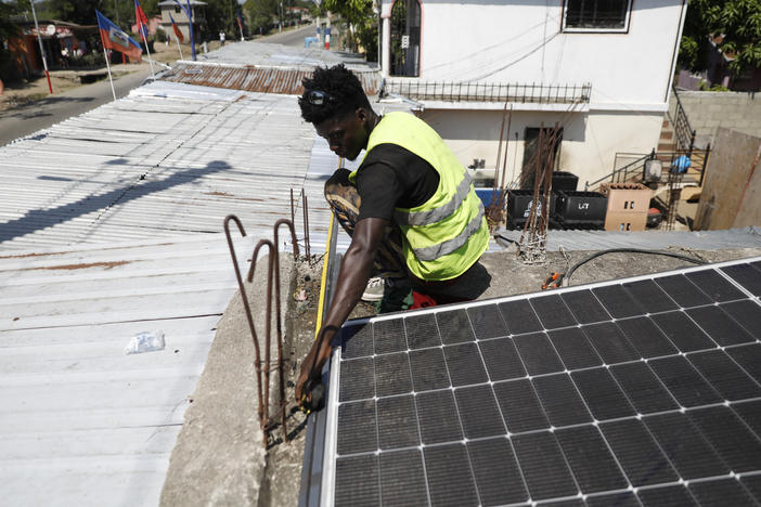 Rod Augustin, measures dimensions for solar panel installation at a local bar in Limonade, Haiti, on March 17, 2024.
