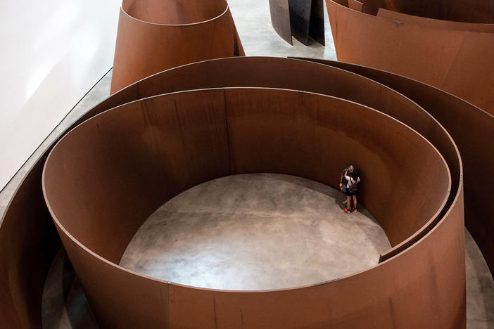 Visitors look at the artwork "The Matter of Time" by US artist Richard Serra during the presentation of the "25 Years of the Museum Collection" exhibition on the 25th anniversary of the Guggenheim Museum Bilbao in the Spanish Basque city of Bilbao on Oct. 18, 2022.