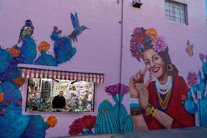 Evan Kory, one of the owners of La Cinderella and Kory bridal store, peers out of the window as the shops close in downtown Nogales.