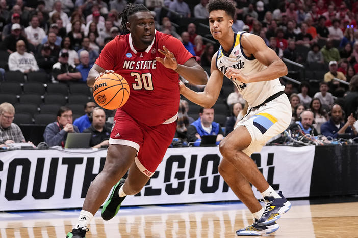 North Carolina State's DJ Burns Jr. (left) drives against Marquette's Oso Ighodaro during their Sweet 16 game in the men's NCAA Tournament in Dallas on Friday.